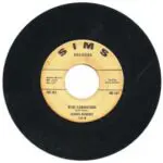 A black and yellow record with some writing on it