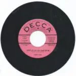 A pink and black record with the words " decca " on it.