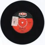 A black and red record with the label for the album.