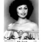 A black and white photo of a woman with big hair.